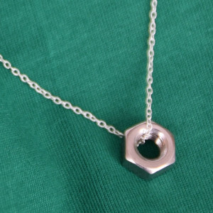 Halsband med tunn silverkedja och mutter i rostfritt stål.